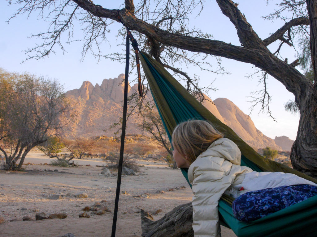 Sophia in der Hängematte mit Blick auf die rote Gebirgskette in Spitzkoppe