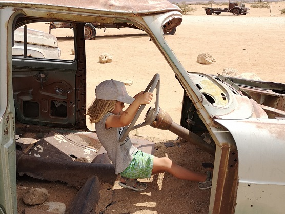 Amélie in einem alten Autowrack in Solitaire, Namibia
